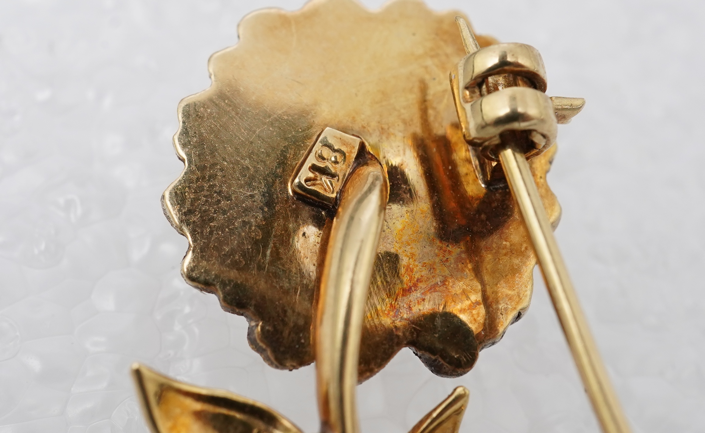 Two brooches and a ring, mid 20th century, comprising: a brooch of floral design, set with circular-cut synthetic gemstones, length 3.7cm, Austrian assay marks for gold, gross weight approximately 6.5 grams; a brooch des